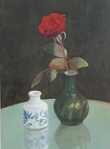 rote Rose neben weisser Vase